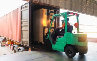 Forklift driver loading goods pallet into the truck container, freight industry warehouse logistics and transport